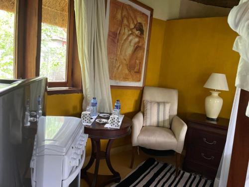 a living room with a table and a chair and a television at Nzuri House in Nairobi