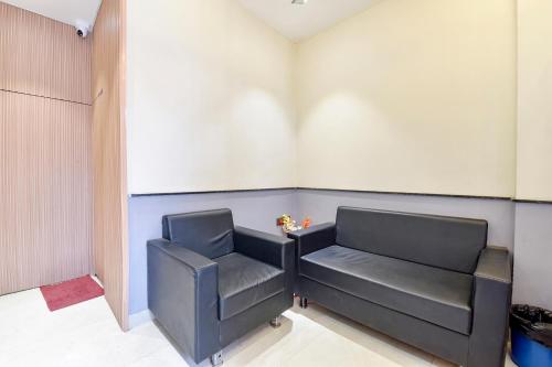 a waiting room with a black chair in a room at FabExpress Kesar in Indore