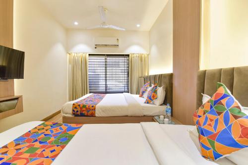 a hotel room with two beds and a window at FabExpress Kesar in Indore