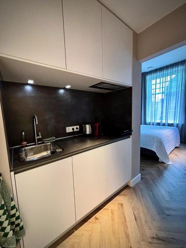 a kitchen with a sink and a bed in a room at Boutique Pastorale in Linschoten