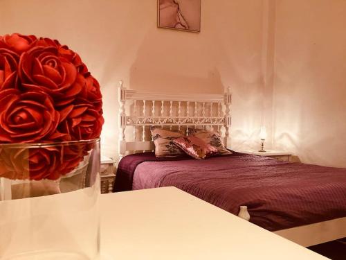 a bedroom with a bed and a large red rose at Casa Glória in Cabeceiras de Basto