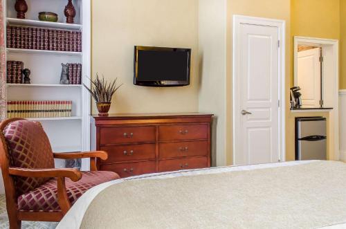 a bedroom with a bed and a tv on a wall at The Federal Pointe Inn Gettysburg, an Ascend Collection Hotel in Gettysburg