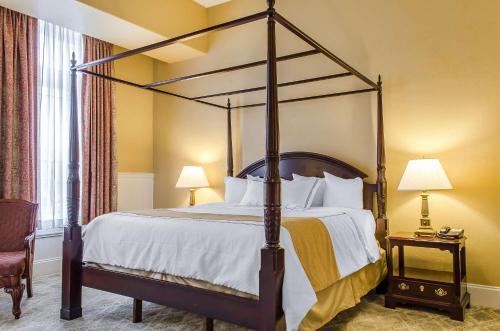 a bedroom with a canopy bed with white pillows at The Federal Pointe Inn Gettysburg, an Ascend Collection Hotel in Gettysburg