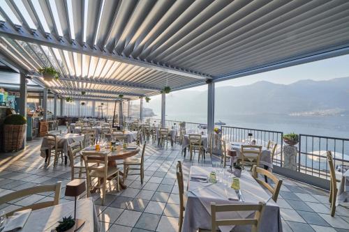 Un restaurante con mesas y sillas en un balcón. en Lakeview Jonny house on the roofs, en Lezzeno