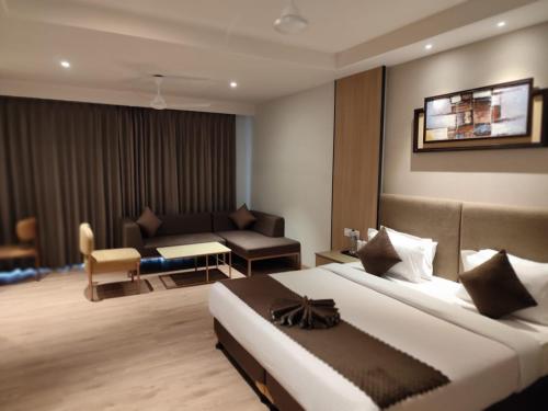 a hotel room with a bed and a living room at ANNTILIA INN in Ludhiana