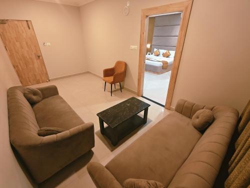 a living room with a couch and a table at Hotel MGM Grand in Srikalahasti