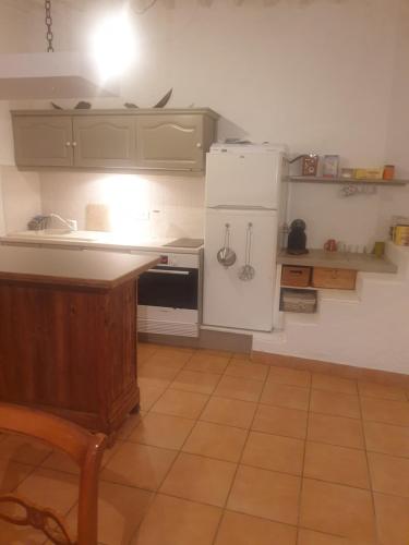 a kitchen with a white refrigerator and a stove at la source fraiche in Notre-Dame-de-la-Rouvière