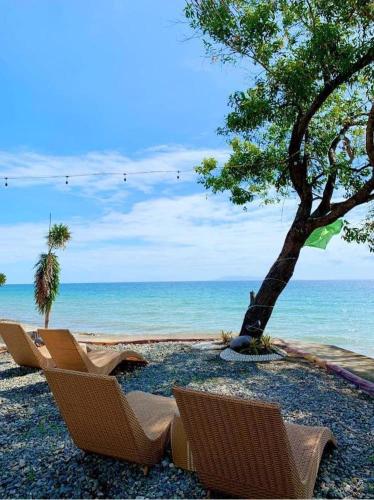 two chairs sitting on the beach near the ocean at Anelasplace Beach Resort in Bansud