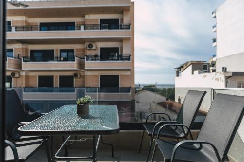 a table and chairs on a balcony with a building at Home Avenue in Alexandroupoli