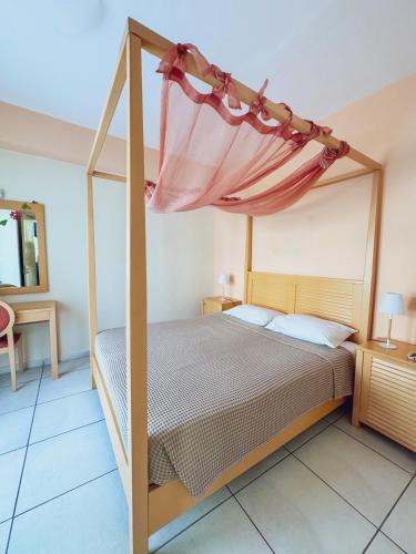 a bedroom with a bed with a canopy at Emporios Bay Hotel Chios in Emporeios