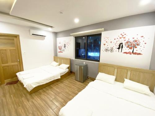 a room with two beds and a painting on the wall at Jolilian Homestay Vũng Tàu in Vung Tau