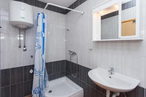 a bathroom with a sink and a toilet and a mirror at 2 bedroom apartment with Sea view in Trstenik