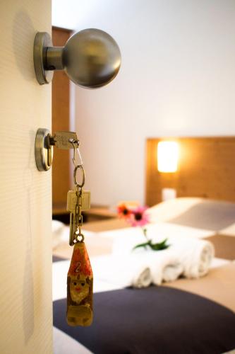 a key hanging from a door with a bed at Agriturismo Monte Del Re in San Pietro al Natisone