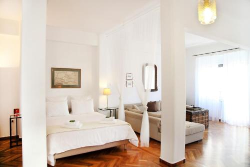 a white bedroom with a bed and a mirror at My Athens House in Athens