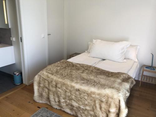 a bedroom with a bed with a blanket on it at Haabakk on Sea in Tau