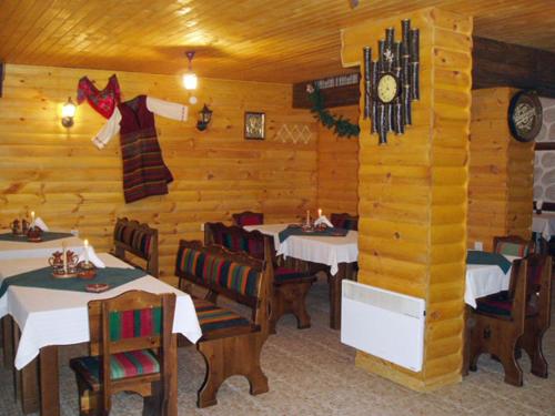 a restaurant with tables and a clock on the wall at Apartments & Studios Mountain Romance in Bansko
