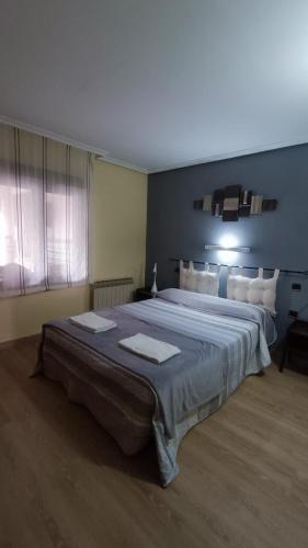 a bedroom with a large bed with two towels on it at Casa Alda in Cabezuela