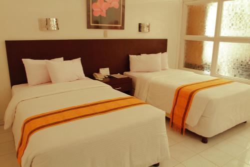 a hotel room with two beds and a window at Khas Parapat in Parapat