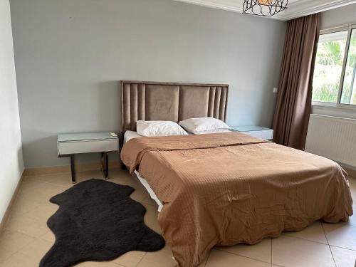 Un dormitorio con una cama grande y una alfombra. en Duplex cornish lac2, en Túnez