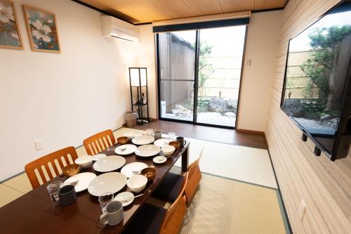 a dining room with a table and a large window at JPRESERVE Bishamoncho in Kyoto
