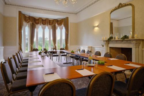 a large dining room with a long table and chairs at Delta Hotels by Marriott Breadsall Priory Country Club in Derby