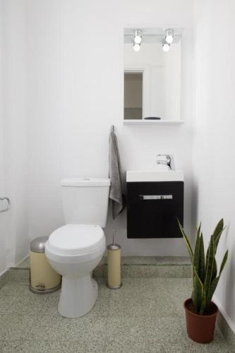 a white bathroom with a toilet and a sink at My Athens House in Athens