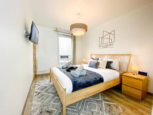 - une chambre avec un grand lit et une télévision dans l'établissement Bussy Gray Spot - RER Centre & Parking, à Bussy-Saint-Georges