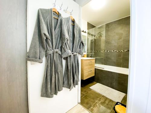 La salle de bains est pourvue d'un peignoir suspendu à une porte. dans l'établissement Bussy Gray Spot - RER Centre & Parking, à Bussy-Saint-Georges