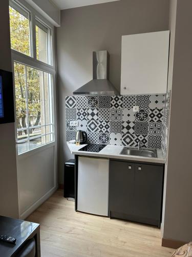 une petite cuisine avec un évier et une fenêtre dans l'établissement PRESTIGE HOME Metz GARE, à Metz