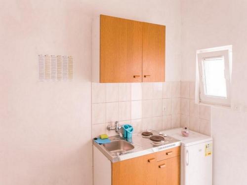 a small kitchen with a sink and a refrigerator at Apartments Franka Saplunara-One-Bedroom Apartment with Terrace and Sea View No1 in Saplunara