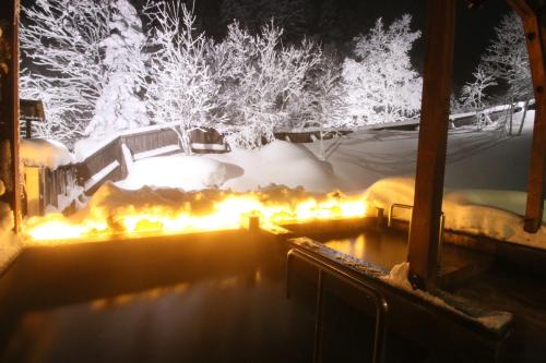 a hot tub in the snow at night at Furano Shiyuirin in Kami-furano