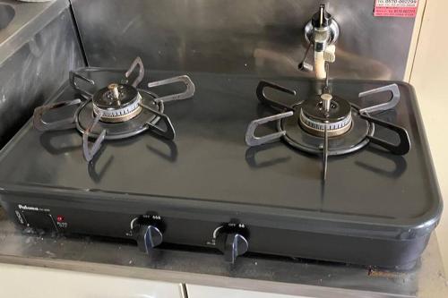 a stove top with two pans on top of it at 完全プライベートルーム 東京 府中駅徒歩圏内 高速フリーWifi キッチン洗濯機完備 二人でも宿泊可 in Fuchu
