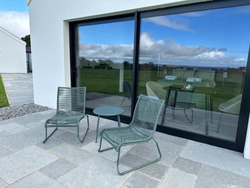 three chairs and a table on a patio with a view at Lough View in Aldergrove