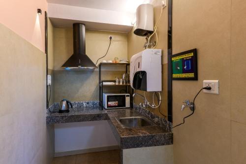 a small kitchen with a sink and a microwave at Heritage View in Ooty