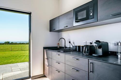 a kitchen with a sink and a microwave above a counter at Lough View in Aldergrove