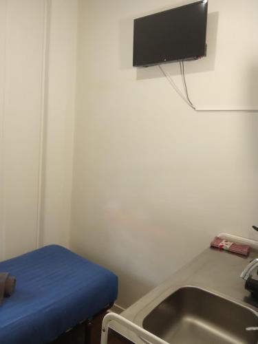 a room with a sink and a tv on the wall at Amoreiras Lisbon Apartments in Lisbon