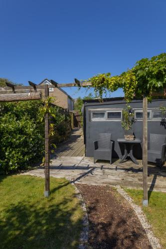 a backyard with a table and a trailer at Bed & Breakfast 28 Appartement met Privé Tuin in Assen