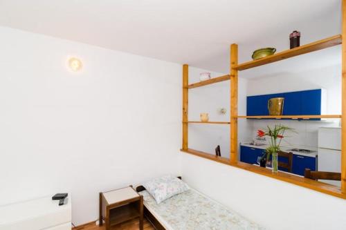 a living room with a couch and shelves at Apartments Bezek - Studio Apartment with Sea View in Trstenik