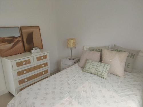 ein Schlafzimmer mit einem Bett mit einer Kommode und einem Spiegel in der Unterkunft Casa de Verão no Condomínio Porto Coronado in Xangri-lá