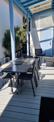 un patio avec tables et chaises sur une terrasse dans l'établissement La PART des ANGES, à Arcachon