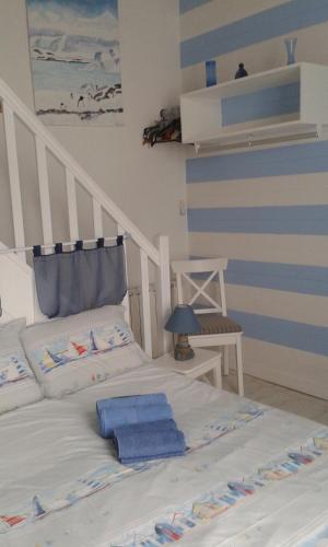 - un lit avec des serviettes bleues dans une chambre dans l'établissement La PART des ANGES, à Arcachon