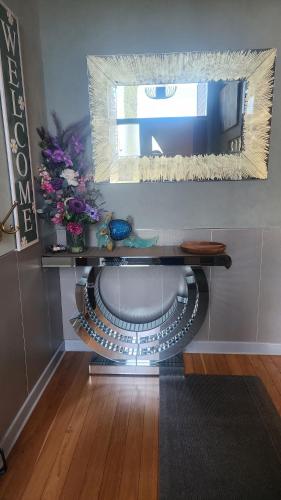 a room with a table with flowers and a mirror at Boutique style accomodation near Busselton Jetty in Busselton