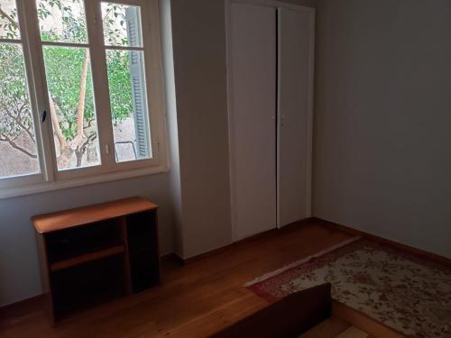 ein leeres Zimmer mit einem Fenster und einem Tisch in der Unterkunft Work, relax, enjoy - SHARED APARTMENT in Athen