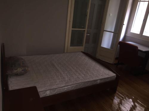 Bett in einem Zimmer mit Fenster und Tür in der Unterkunft Work, relax, enjoy - SHARED APARTMENT in Athen