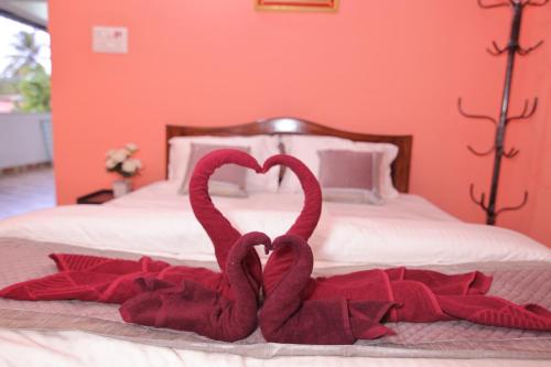 two towels in the shape of hearts on a bed at Margaritas Residency in Benaulim