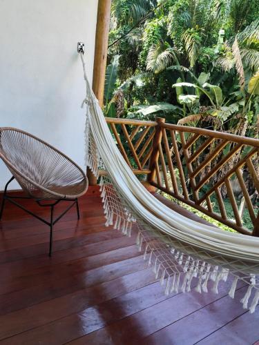 a hammock on a balcony with a chair at Flat novo na Rua Principal, Itacaré BAHIA in Itacaré