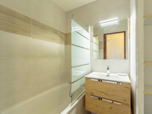 une salle de bain avec un lavabo, une baignoire et un miroir dans l'établissement Charmant 2 pièces rénové, accès skis aux pieds, proche commerces et remontées, balcon sud-ouest - FR-1-353-23, à La Plagne