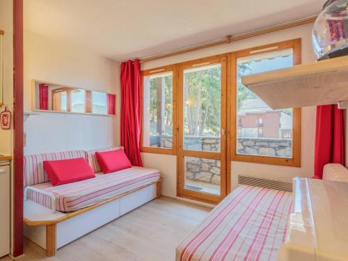 un salon avec un canapé et une fenêtre dans l'établissement Charmant 2 pièces rénové, accès skis aux pieds, proche commerces et remontées, balcon sud-ouest - FR-1-353-23, à La Plagne