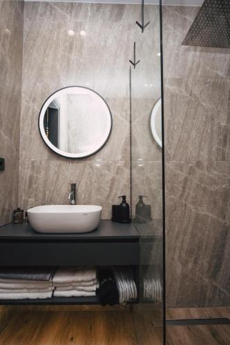 a bathroom with a sink and a mirror at Home Avenue in Alexandroupoli