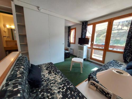 Cette chambre d'hôtel dispose d'un lit, d'une télévision et d'une chambre. dans l'établissement Charmant 2P à La Plagne, balcon sud, proche pistes et commerces, équipé pour 4 pers. - FR-1-353-119, à La Plagne Tarentaise